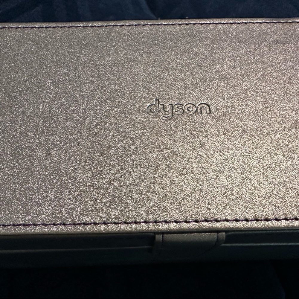 Dyson hair dryer case and two attachments.